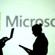 Logo de Microsoft avec des personnes regardant leurs ordinateurs