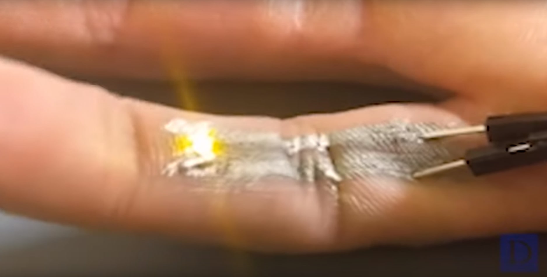 De l'encre conductrice imprimée sur un doigt allumant une petite LED