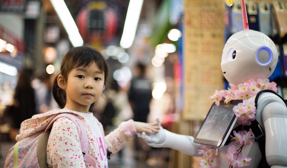 Une petite fille donnant la main à un robot intelligent