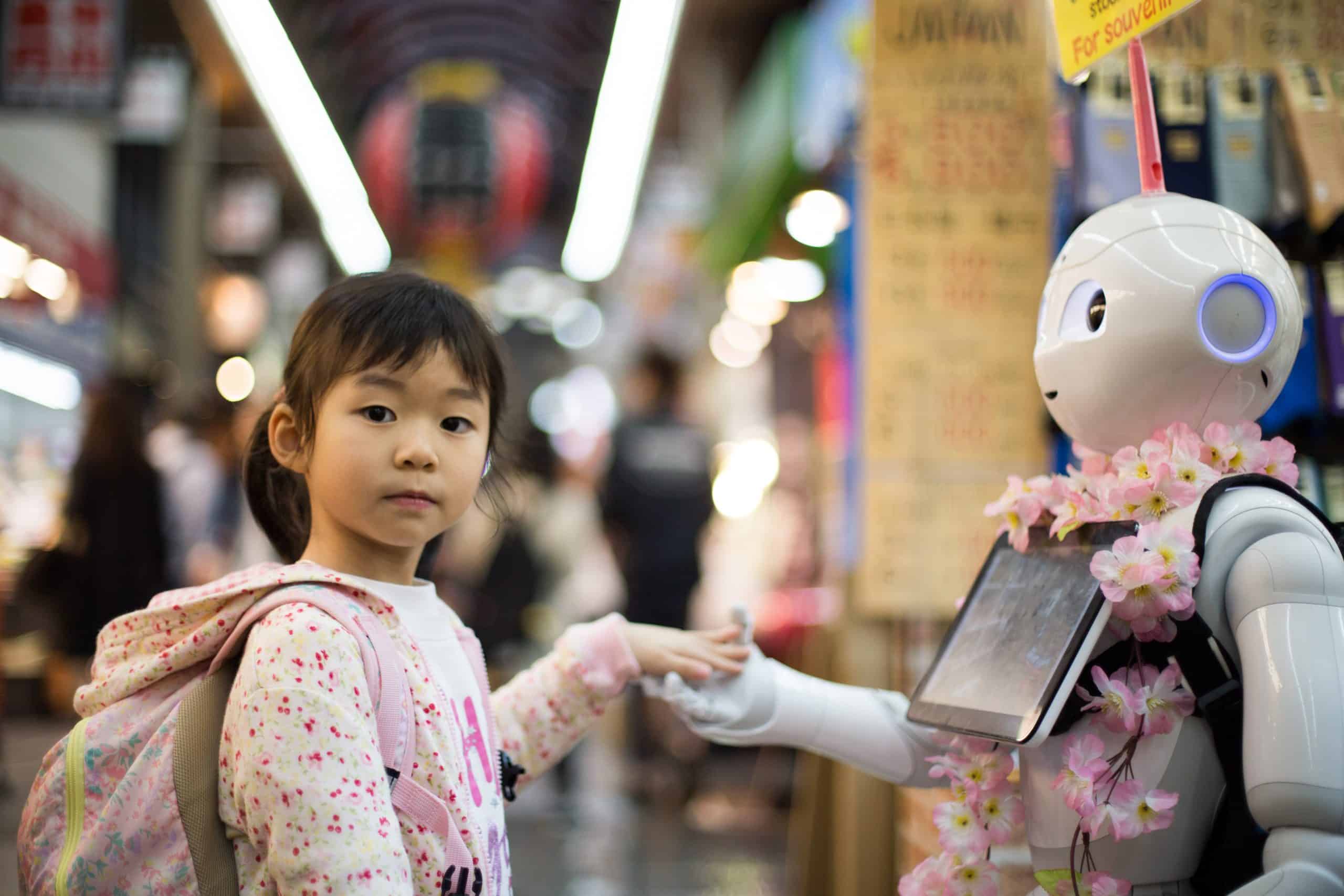 Une petite fille donnant la main à un robot intelligent