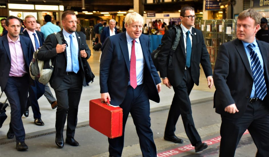 Le premier ministre britannique, Boris Johnson, marche dans la rue accompagné de ses conseillers.