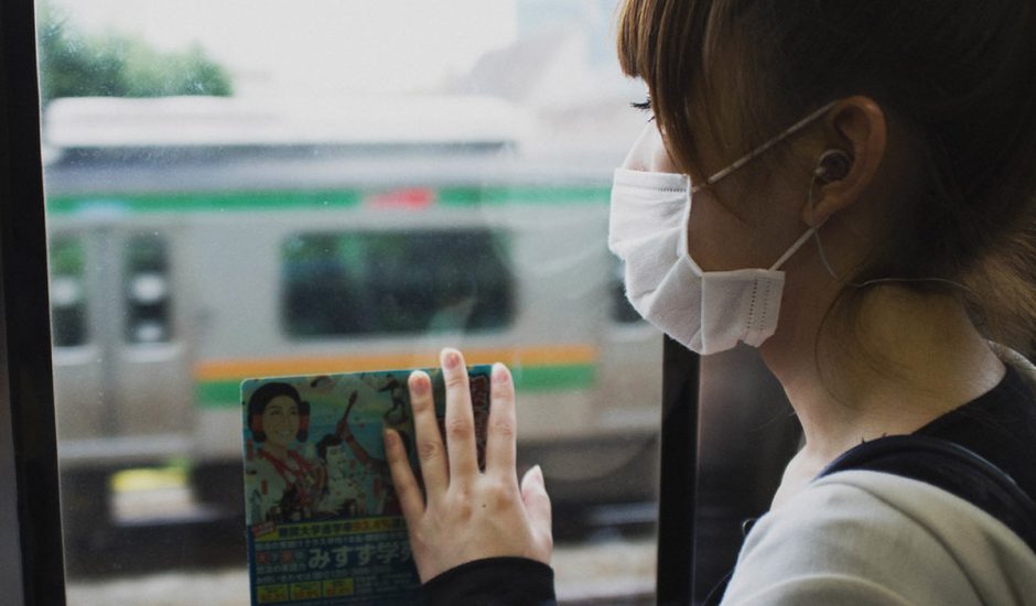Une femme avec un masque chirurgical dans les transports en commun.