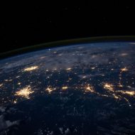 Une photo de la Terre de nuit, on voit les villes éclairées depuis l'Espace