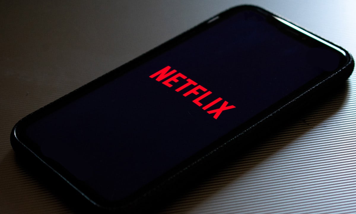Un smartphone posé sur une table qui lance l'application Netflix
