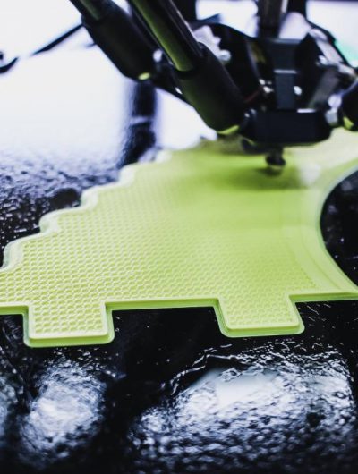 Une imprimante 3D est en train d'imprimer une structure jaune.