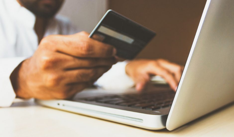 Un homme payant un achat sur internet avec sa carte de crédit.