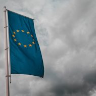 Un drapeau de l’Union Européenne flottant dans un ciel nuageux