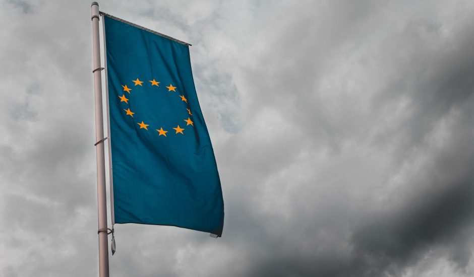 Un drapeau de l’Union Européenne flottant dans un ciel nuageux
