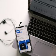 un smartphone posé sur un ordinateur affichant la page de l'application Zoom sur iOS