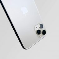 Un iPhone 11 Pro à l'envers sur un fond gris.