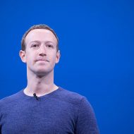 Portait de Mark Zuckerberg se tenant devant un fond bleu.