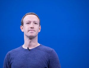 Portait de Mark Zuckerberg se tenant devant un fond bleu.