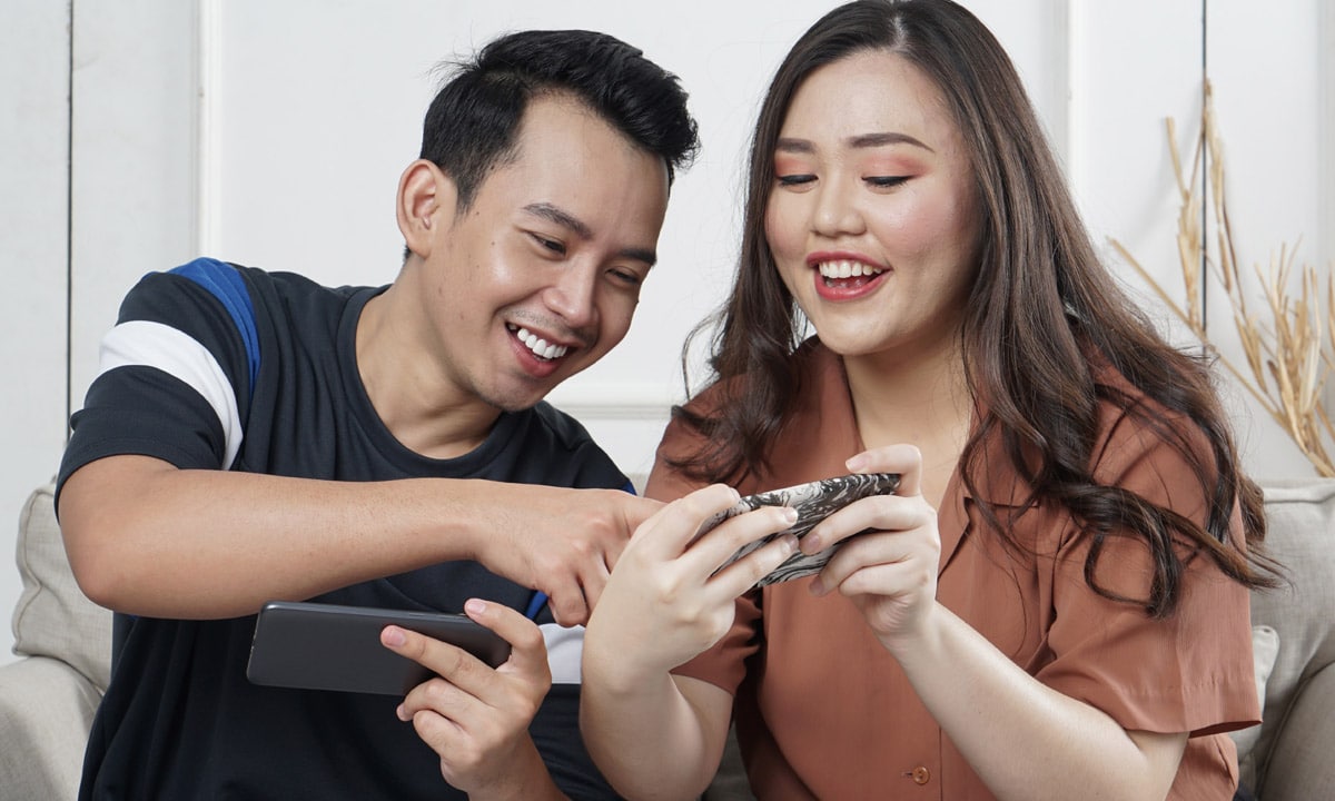 Deux personnes jouant à des jeux vidéo sur leurs smartphones.