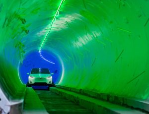 Une voiture Tesla blanche roule dans un tunnel.