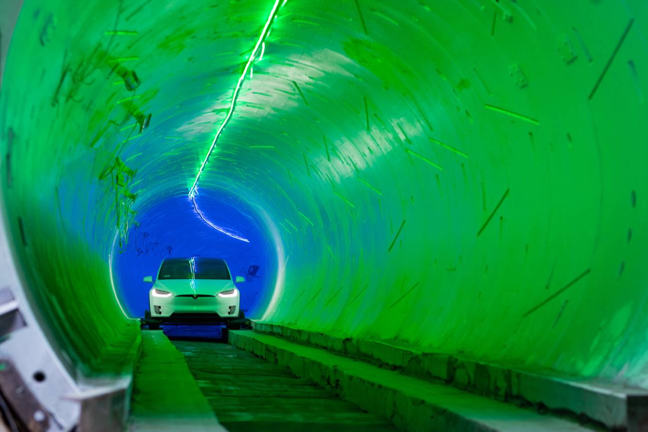 Une voiture Tesla blanche roule dans un tunnel.