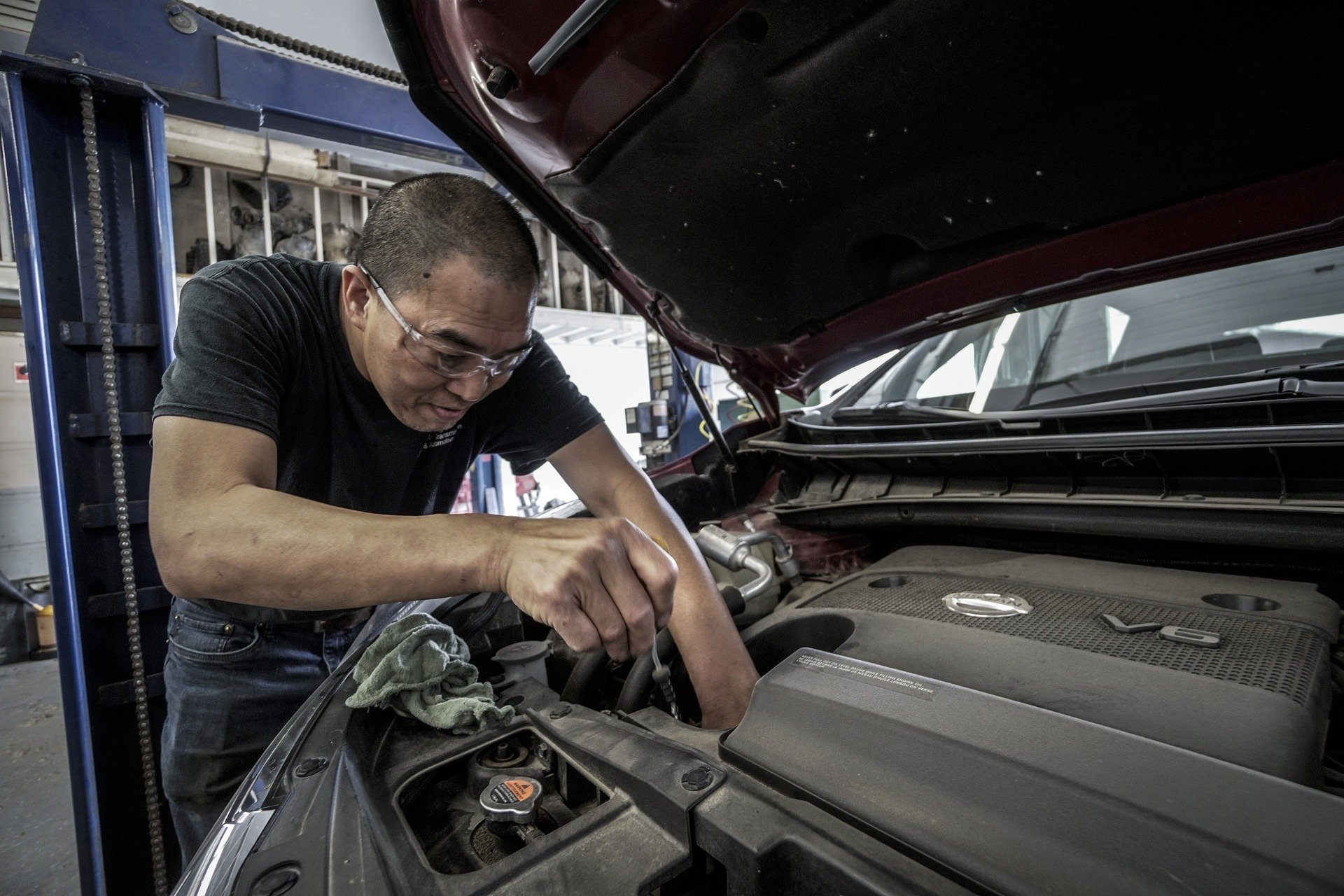 Un garagiste répare le moteur d'une voiture.