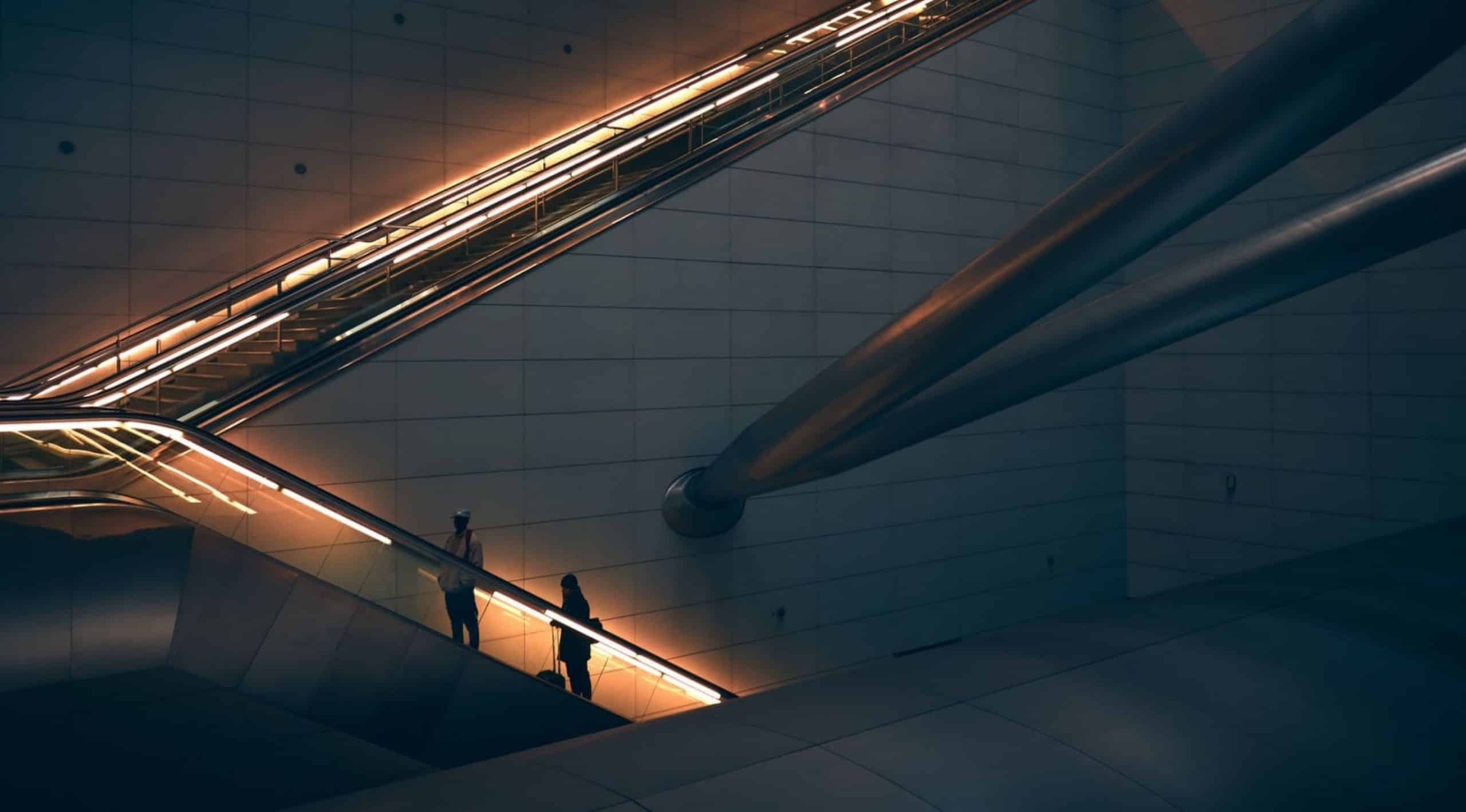 deux personnes montant un escalator