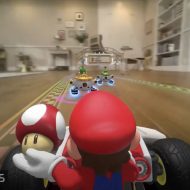 Le personnage Mario est dans un karting, tient un champignon dans la main et parcourt un circuit dans un salon.