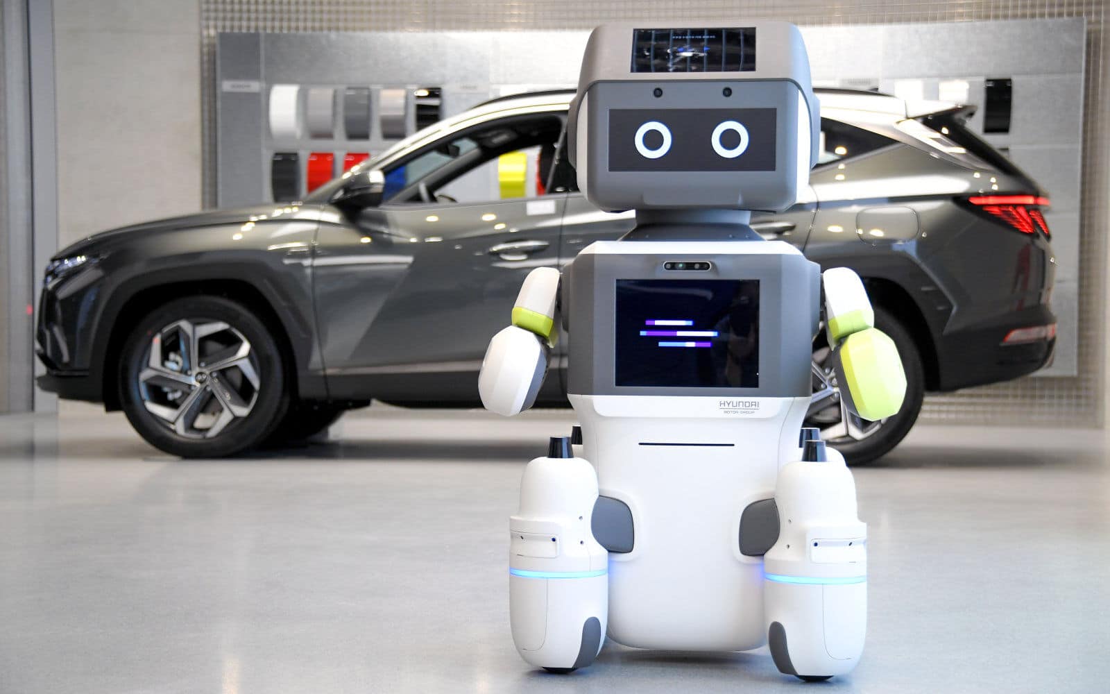 Le robot DAL-e se tient devant une voiture Hyundai.