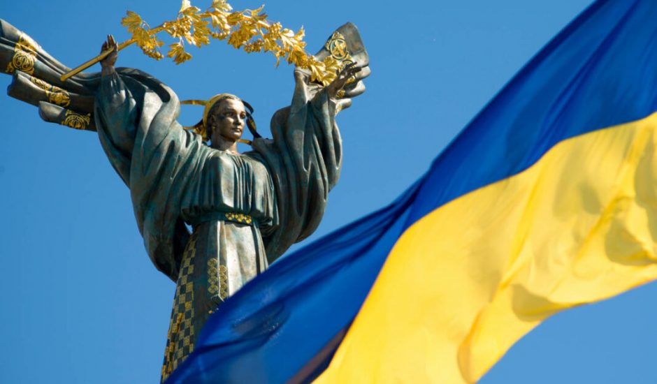 drapeau de l'Ukraine avec en arrière plan une statut