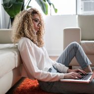 une jeune femme avec son laptop sur la moquette