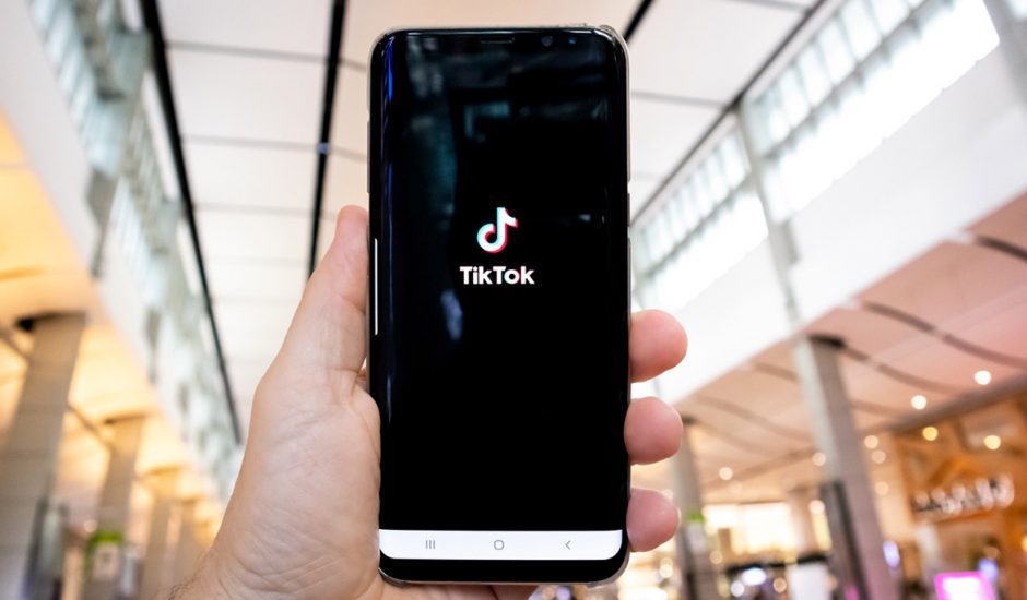 TikTok Une personne tient un smartphone qui lance l'application.