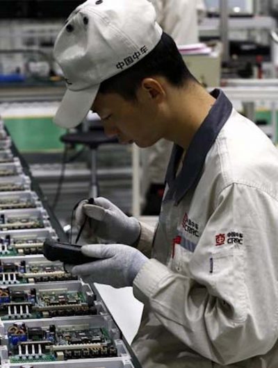 Photographie d'un ouvrier travaillant sur des micro-processeurs.