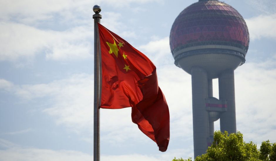Le drapeau chinois devant un édifice à Shanghai.