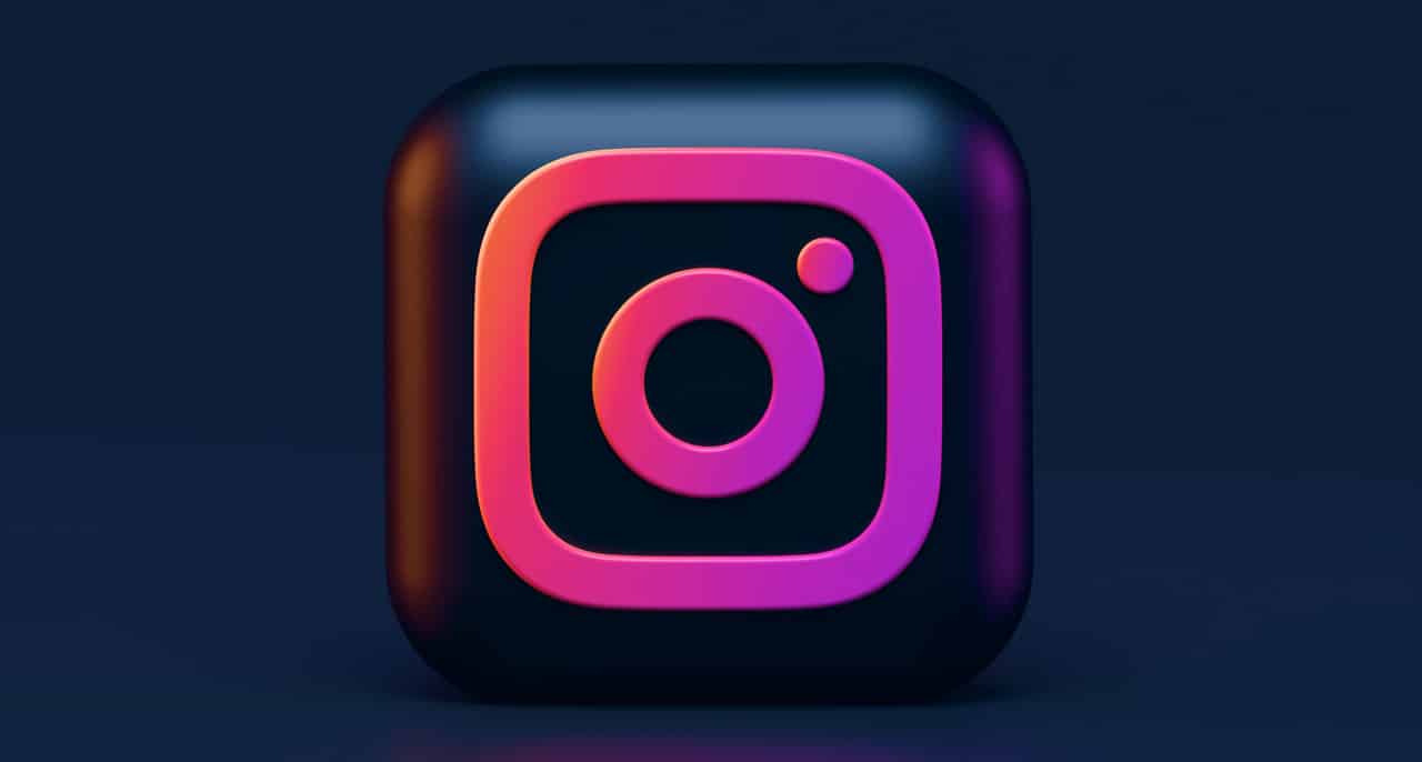 Le logo Instagram en 3D sur un fond bleu noir.
