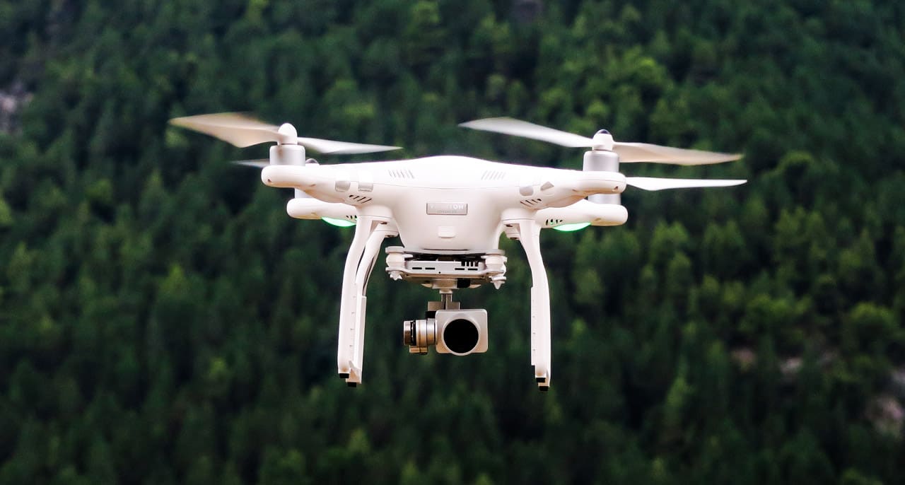 Un drone qui vole au-dessus d'une forêt.