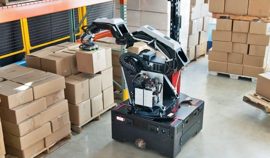 Le robot Stretch de Boston Dynamics soulève des cartons dans un entrepôt.