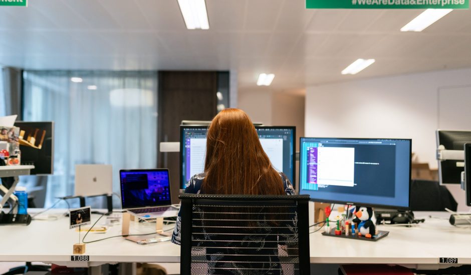 Photographie du femme travaillant sur ordinateur affichant l'interface d'un services cloud.