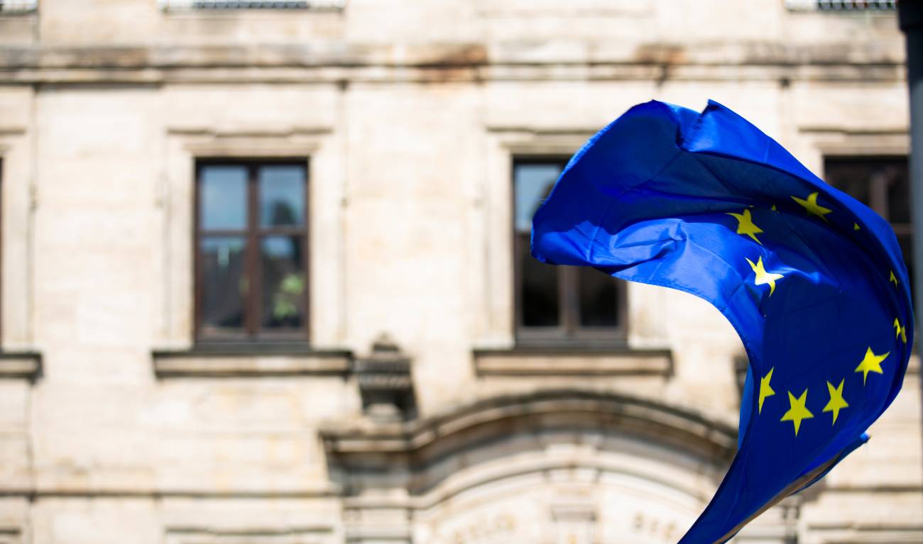 Le drapeau de l'Union européenne flotte devant un bâtiment.