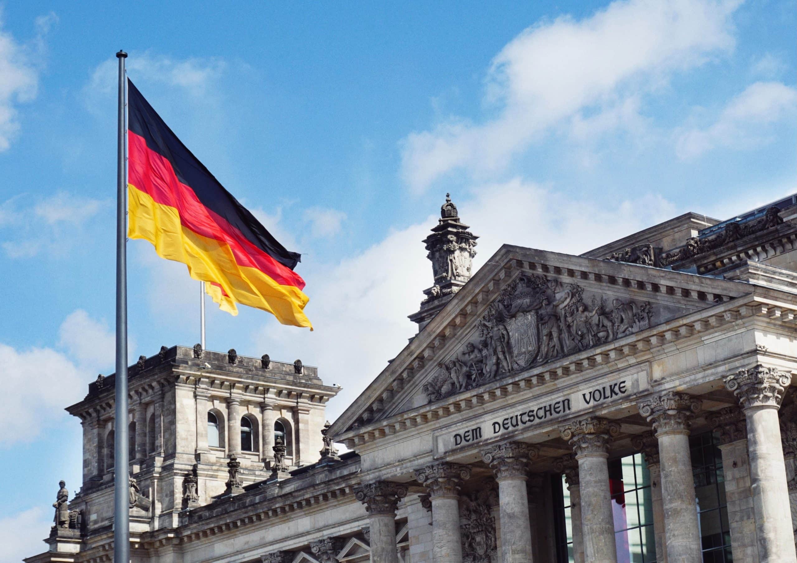 Le drapeau allemand flotte devant un monument.