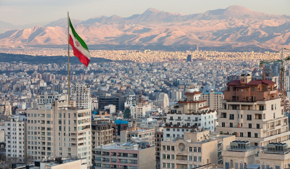 Photographie d'une ville en Iran avec le drapeau de l'Iran.