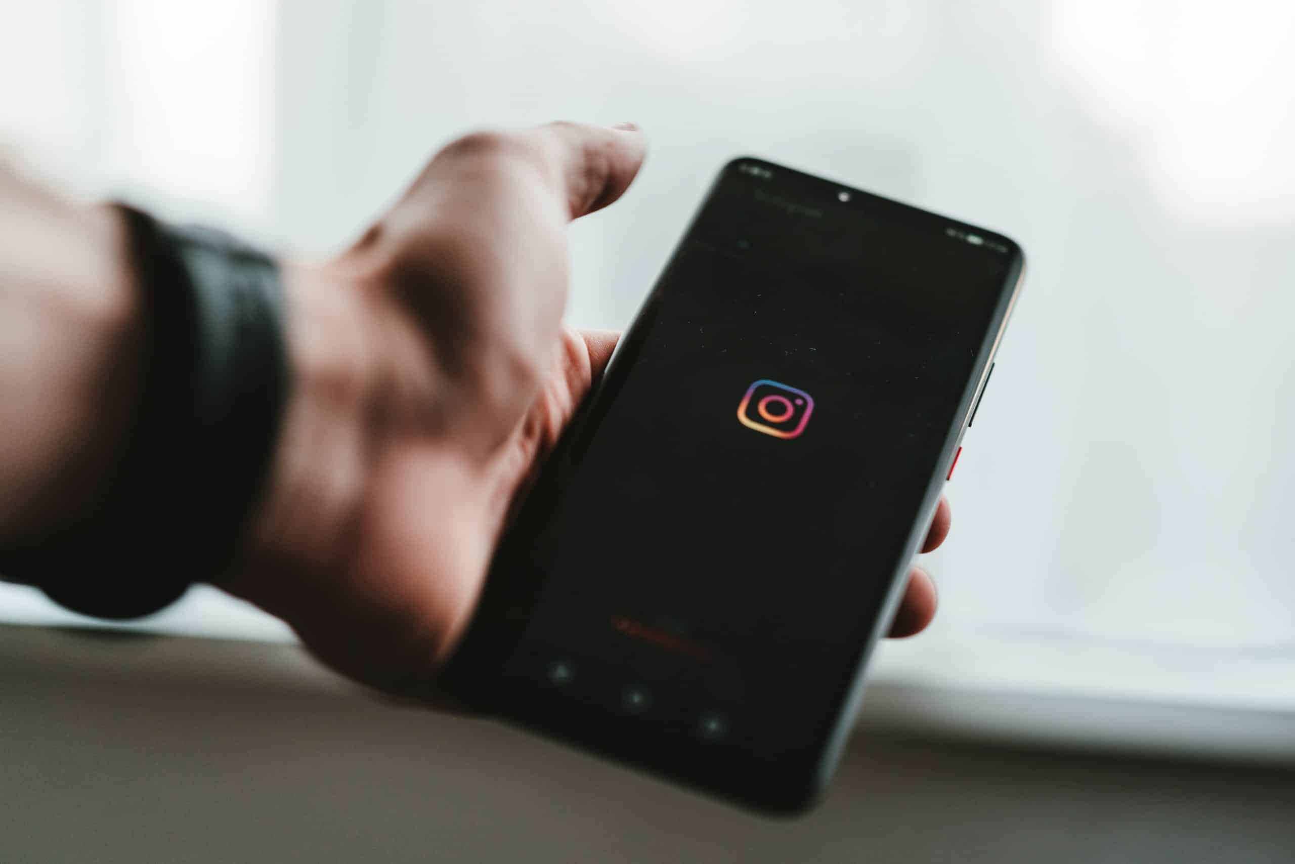 Un homme tient un téléphone lançant l'application Instagram.