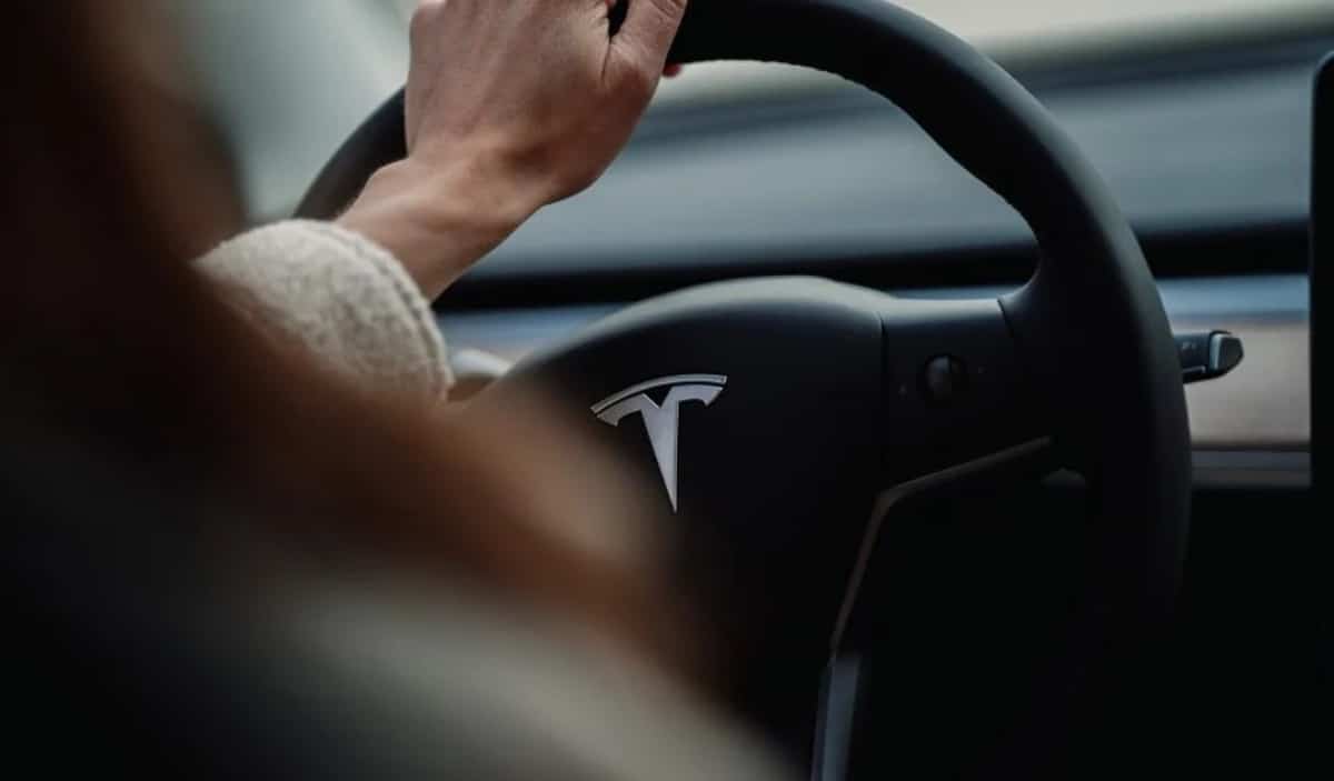 Une conductrice derrière le volant d'une Tesla.