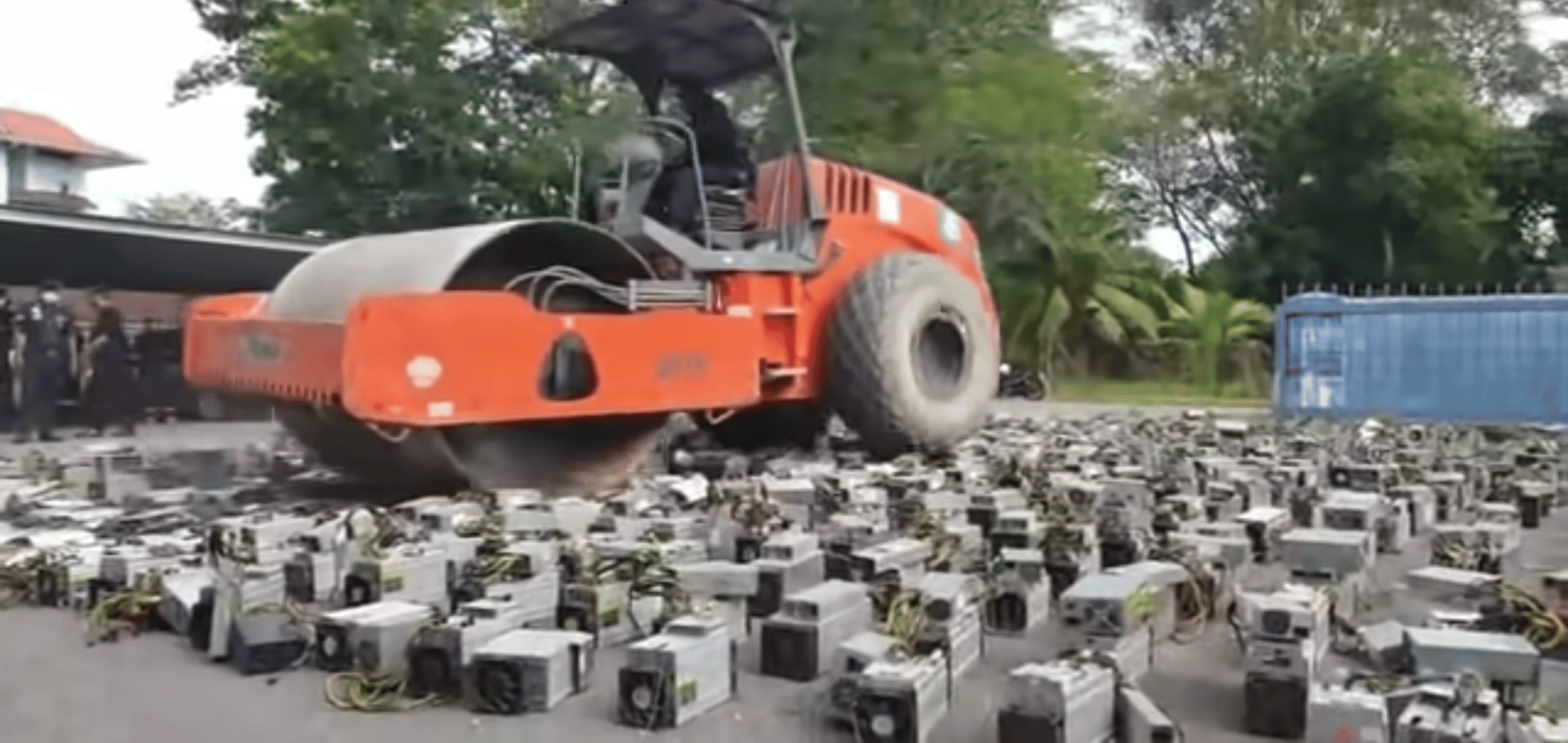 Un bulldozer écrasant des kits de minage de cryptomonnaies