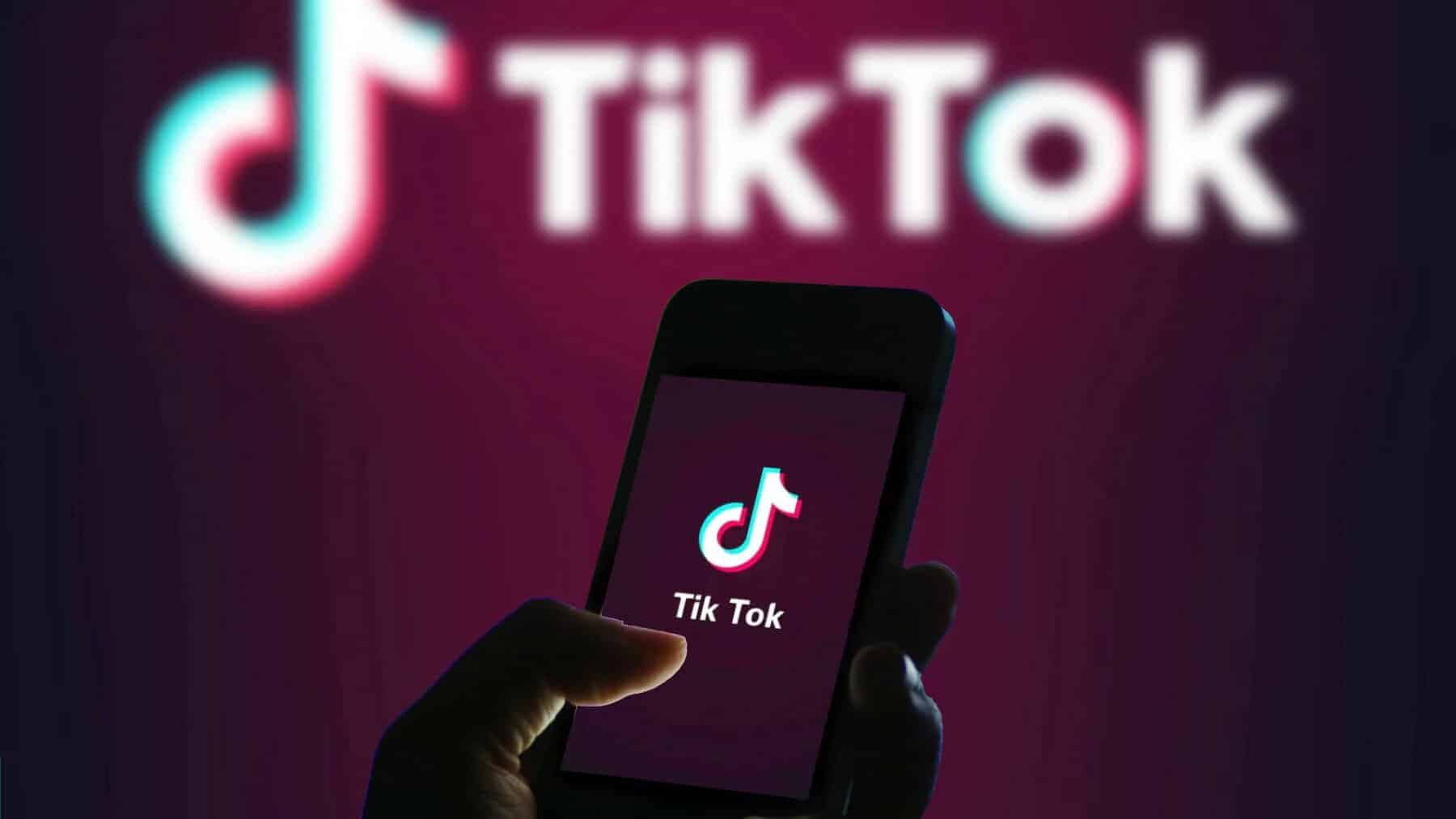 Image d'un téléphone ouvert sur Tiktok avec le logo de la marque derrière. Il est peut être utilisé par un enfant.