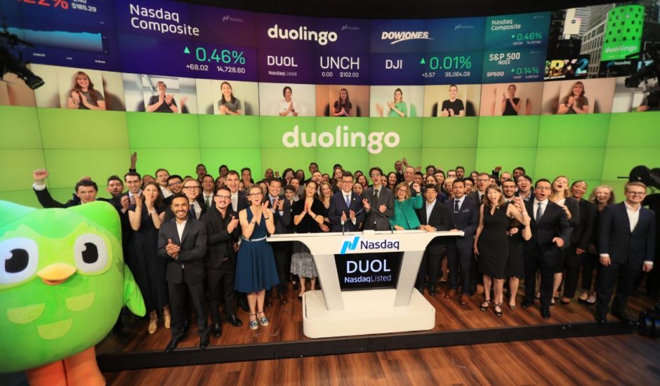 Photographie du co-fondateur et PDG de Duolingo, Luis von Ahn, debout avec un groupe d'environ 100 employés de Duolingo et la mascotte de Duolingo chouette verte.