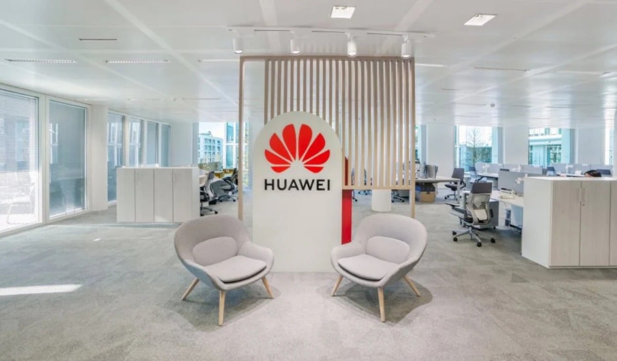 Deux chaises grises devant un panneau Huawei dans les locaux de l'entreprise.