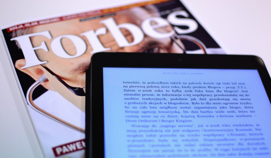 une tablette et un magazine Forbes