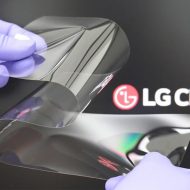 Un verre plié par deux mains ganter devant le logo LG Chem