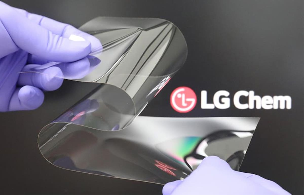 Un verre plié par deux mains ganter devant le logo LG Chem