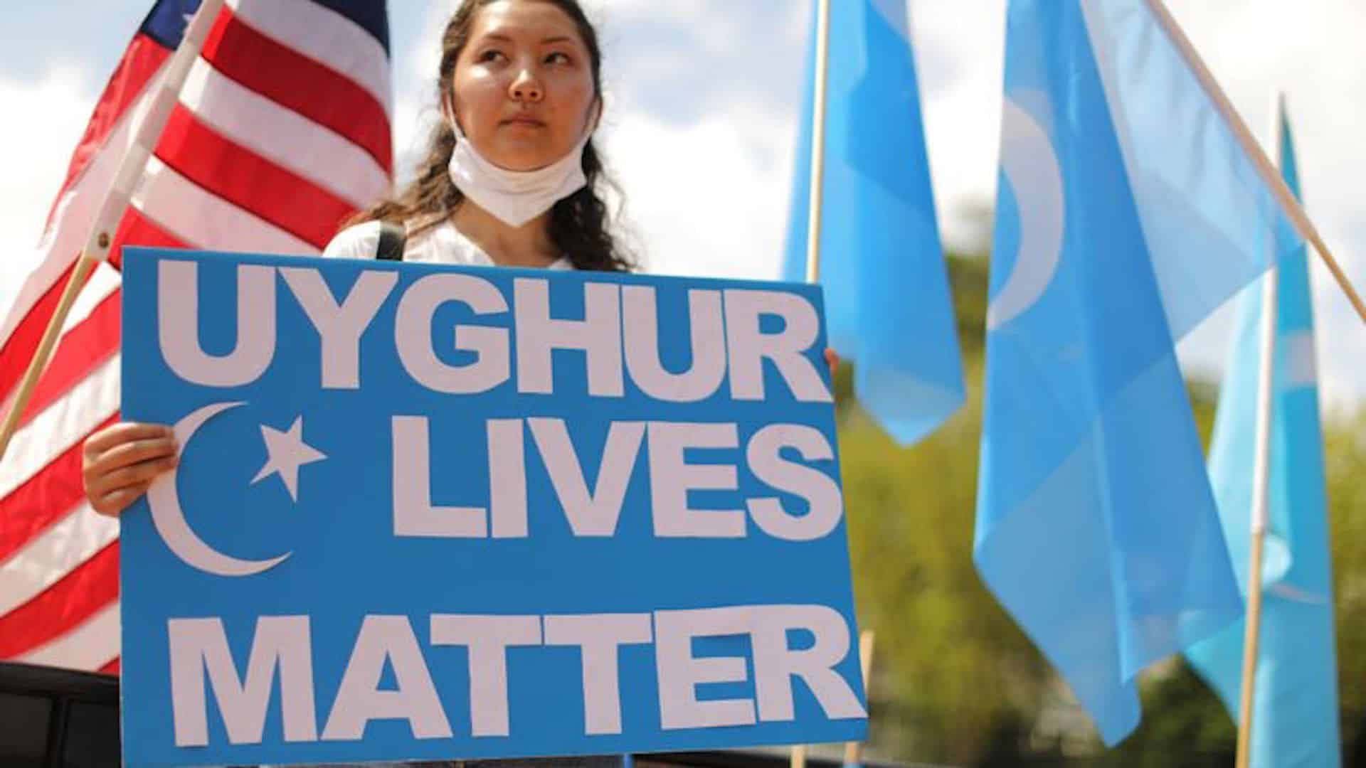 Aperçu d'une femme avec une pancarte pour soutenir les ouïghours.
