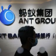 Un employé marche devant le logo d'Ant Group à Hong Kong