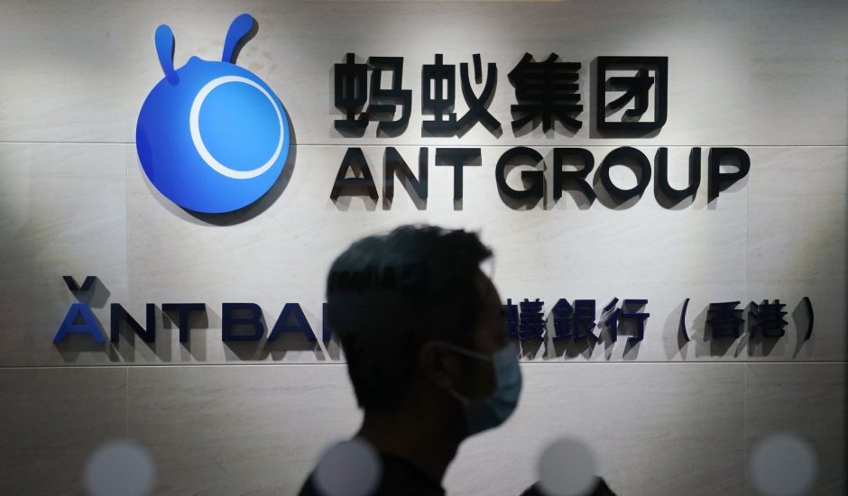Un employé marche devant le logo d'Ant Group à Hong Kong