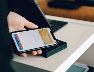 Un individu paie un service ou un objet grâce à l'application Apple Pay disponible sur son iPhone.