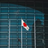 Le drapeau japonais flotte devant un bâtiment.