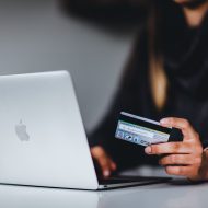 Une femme en train de rentrer les informations de sa carte de crédit dans son ordinateur.